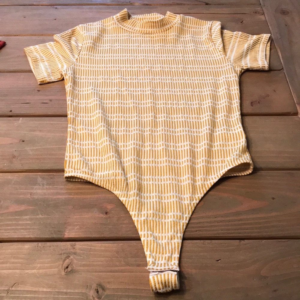 Yellow and white body suit by yellow chair